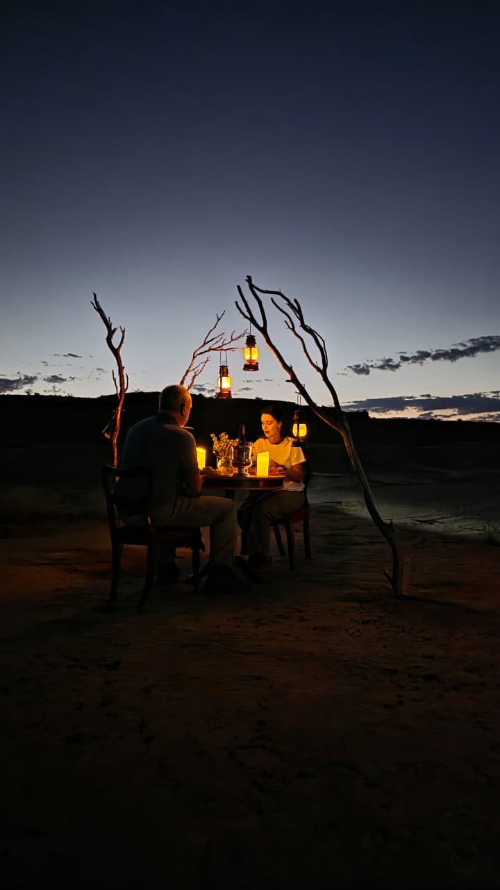 Lantern-lit dinner table in the Kalahari at night